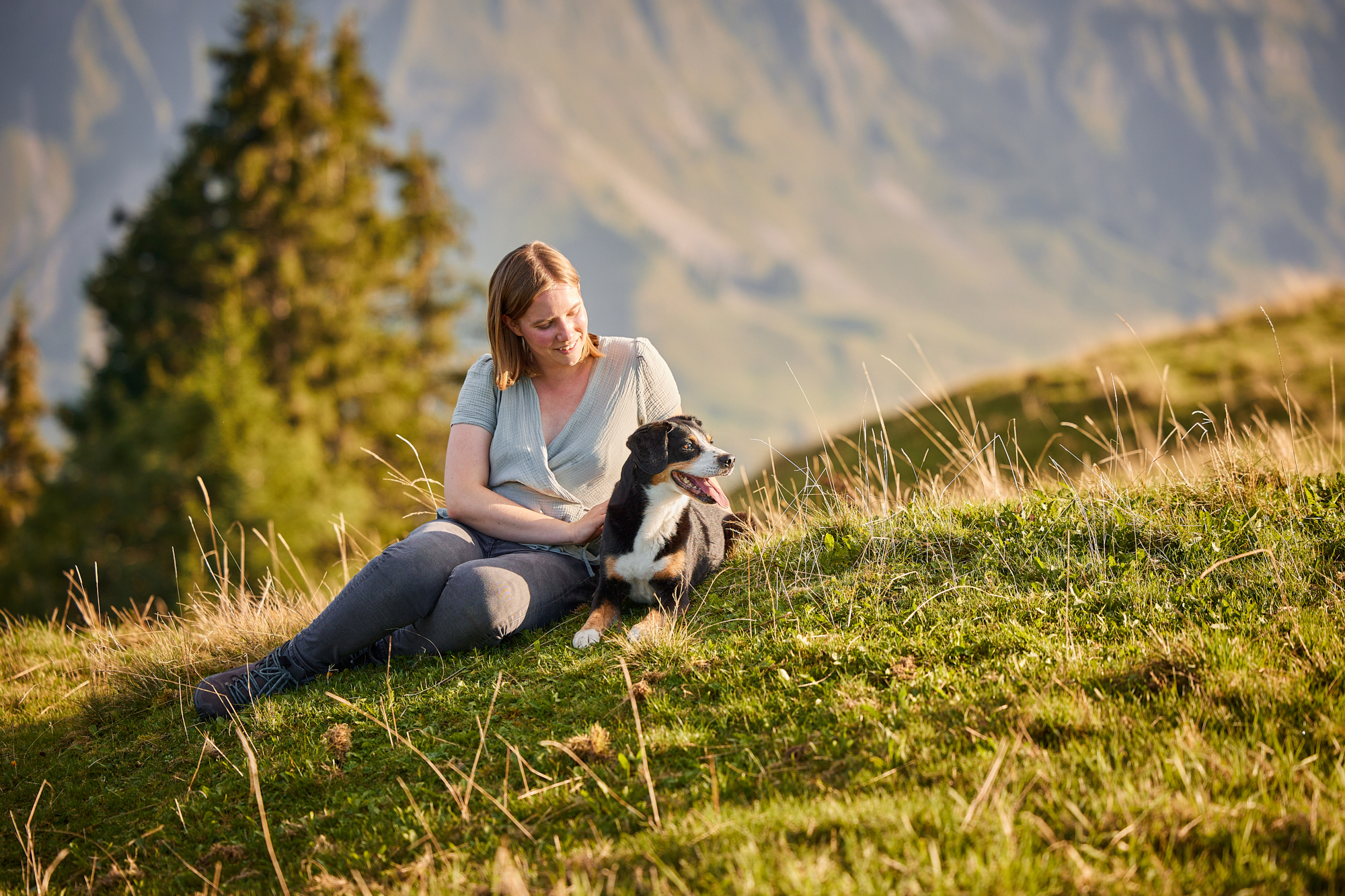 Entlebucher Sennenhund mit Hundebesitzerin bei einem Fotoshooting in Entlebuch in der Schweiz im Sonnenuntergang, professionelles Hunde-Fotoshooting in der Natur