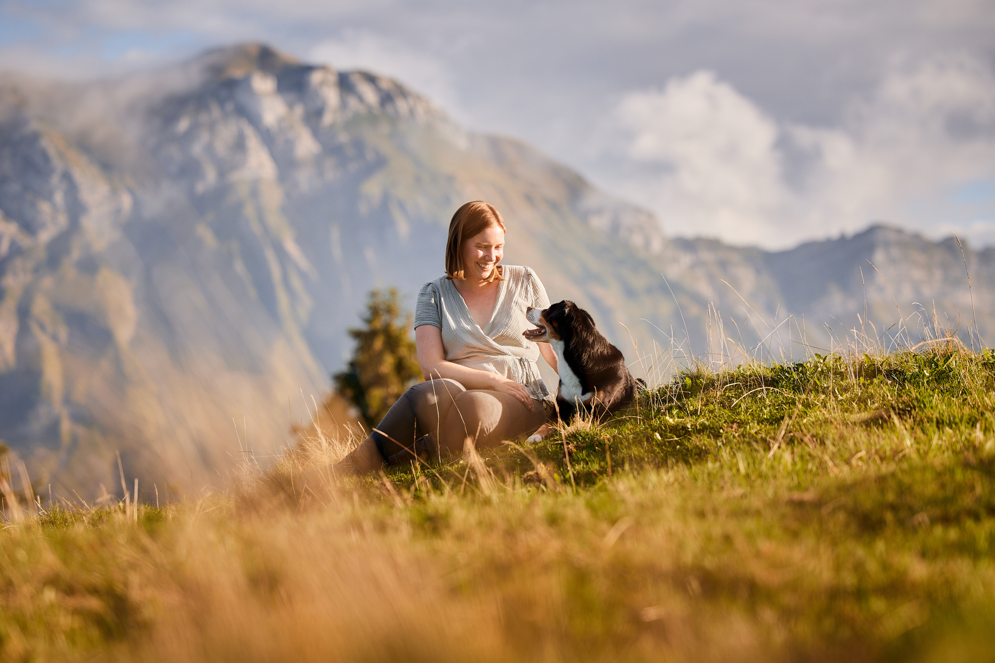 Entlebucher Sennenhund mit Hundebesitzerin bei einem Fotoshooting in Entlebuch in der Schweiz im Sonnenuntergang, professionelles Hunde-Fotoshooting in der Natur