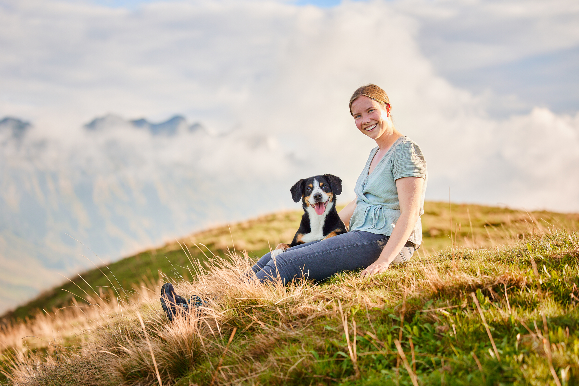 Entlebucher Sennenhund mit Hundebesitzerin bei einem Fotoshooting in Entlebuch in der Schweiz im Sonnenuntergang, professionelles Hunde-Fotoshooting in der Natur