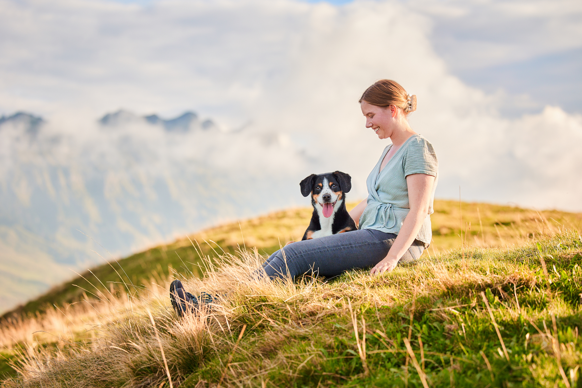 Entlebucher Sennenhund mit Hundebesitzerin bei einem Fotoshooting in Entlebuch in der Schweiz im Sonnenuntergang, professionelles Hunde-Fotoshooting in der Natur