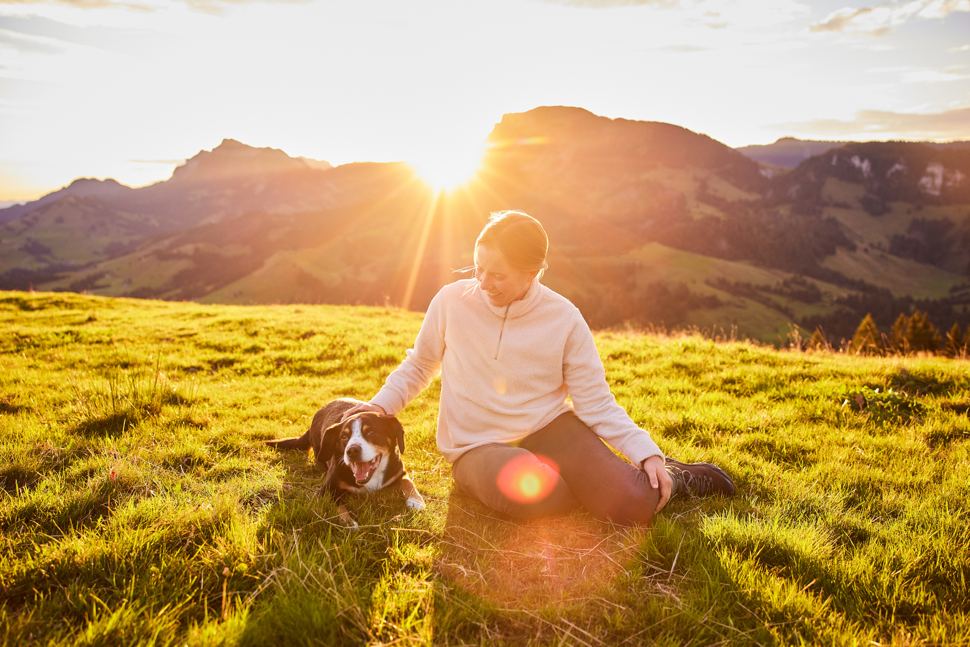 Entlebucher Sennenhund mit Hundebesitzerin bei einem Fotoshooting in Entlebuch in der Schweiz im Sonnenaufgang, professionelles Hunde-Fotoshooting in der Natur