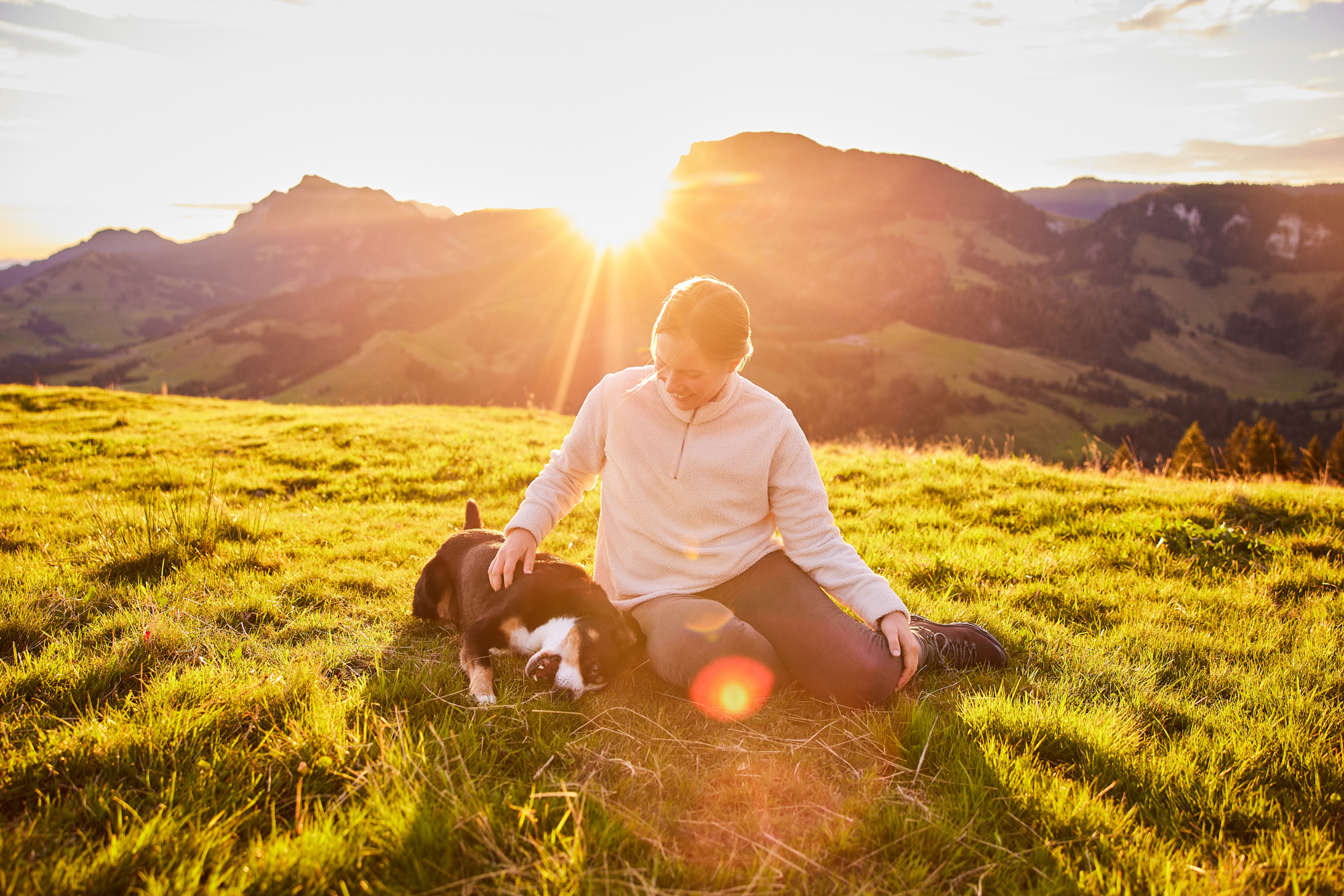 Entlebucher Sennenhund mit Hundebesitzerin bei einem Fotoshooting in Entlebuch in der Schweiz im Sonnenaufgang, professionelles Hunde-Fotoshooting in der Natur