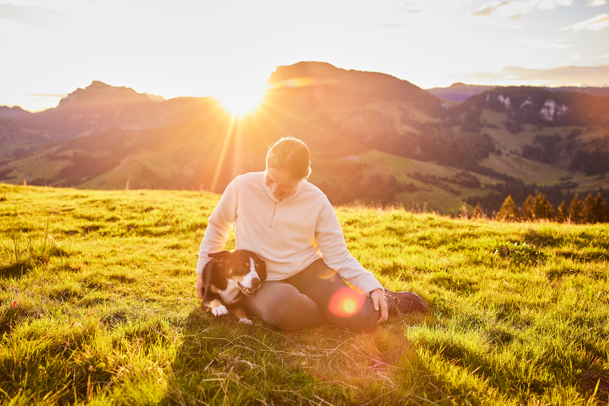 Entlebucher Sennenhund mit Hundebesitzerin bei einem Fotoshooting in Entlebuch in der Schweiz im Sonnenaufgang, professionelles Hunde-Fotoshooting in der Natur