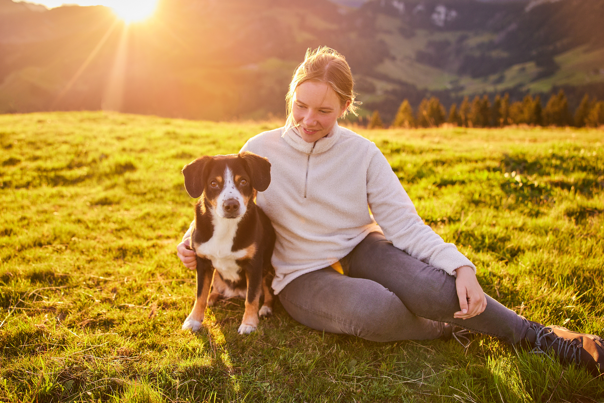 Entlebucher Sennenhund mit Hundebesitzerin bei einem Fotoshooting in Entlebuch in der Schweiz im Sonnenaufgang, professionelles Hunde-Fotoshooting in der Natur