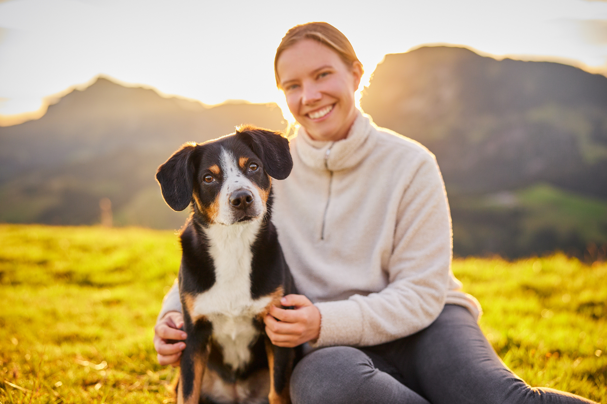 Entlebucher Sennenhund mit Hundebesitzerin bei einem Fotoshooting in Entlebuch in der Schweiz im Sonnenaufgang, professionelles Hunde-Fotoshooting in der Natur
